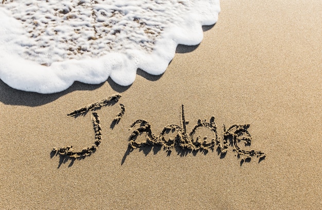 Photo j'adore. une façon de dire français connu mondialement écrit sur le sable