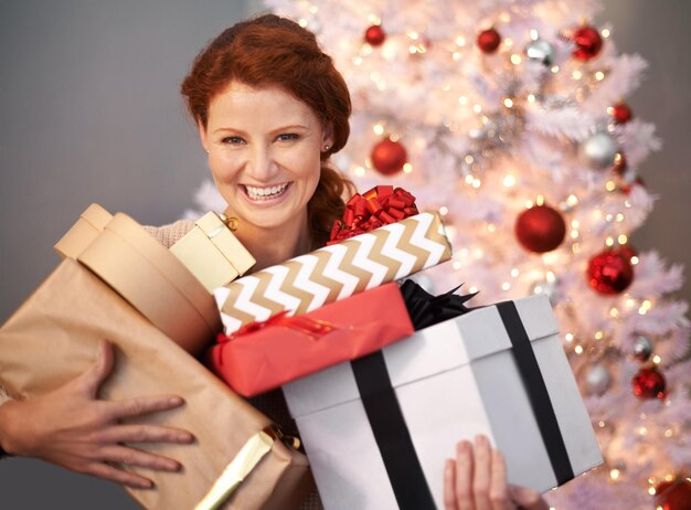 J'ai été gâté ce Noël Portrait d'une jolie jeune femme tenant ses cadeaux de Noël