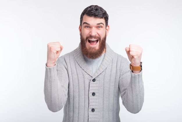 J'ai gagné! Jeune homme fait un geste gagnant sur blanc.