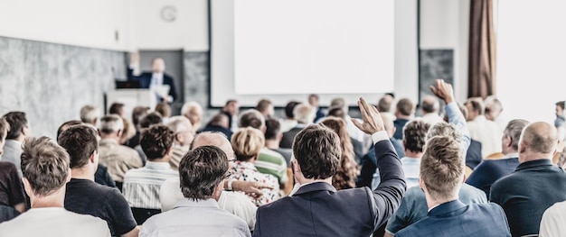 J'ai un groupe de questions de gens d'affaires assis dans la salle de conférence homme d'affaires levant le bras