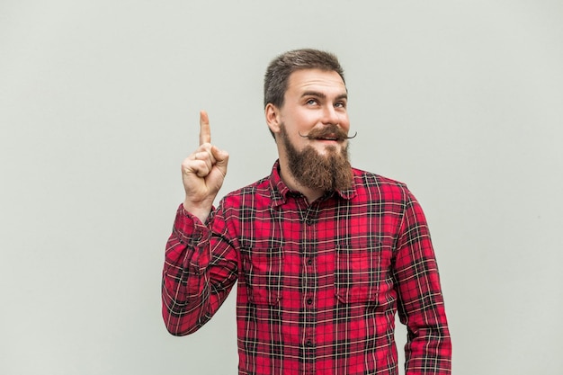 J'ai une idée bel homme d'affaires avec barbe et moustache en guidon regardant la caméra avec le doigt vers le haut