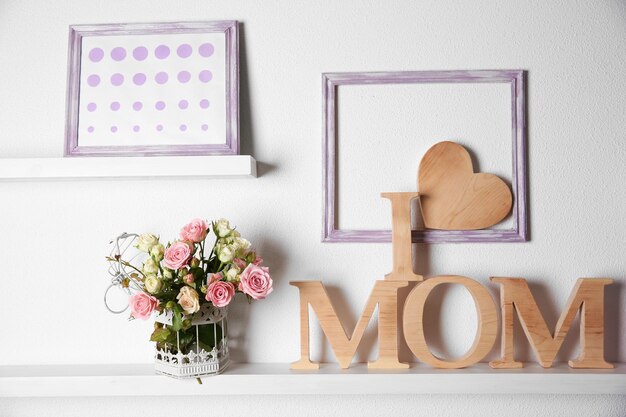 J'aime l'inscription de maman de lettres en bois avec coeur et fleurs sur fond de mur blanc