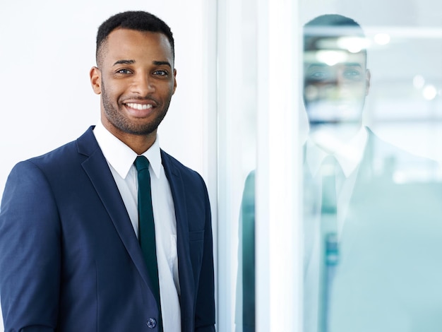 J'aime mon travail Un beau jeune homme d'affaires afro-américain debout à l'intérieur avec un sourire
