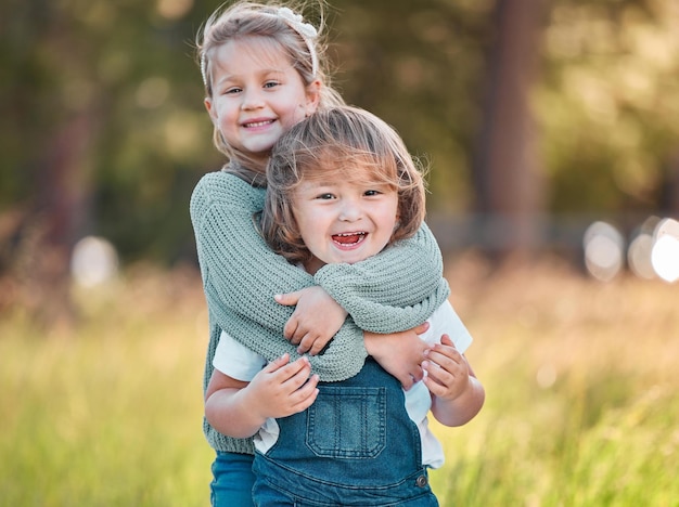 J'aime tellement mon petit frère Photo d'une adorable petite fille et de son petit frère debout à l'extérieur