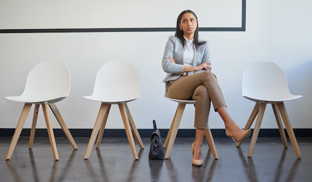 J'espère vraiment que j'obtiendrai ceci. Photo d'une jeune femme qui a l'air malheureuse en faisant la queue dans un bureau.