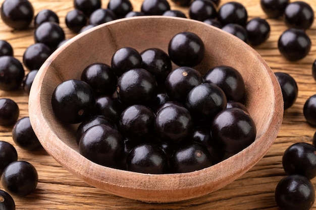 Jabuticabas sur un bol au-dessus d'une table en bois