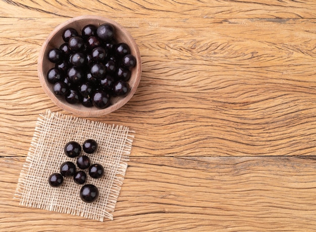 Jabuticabas sur un bol sur une table en bois avec un espace de copie