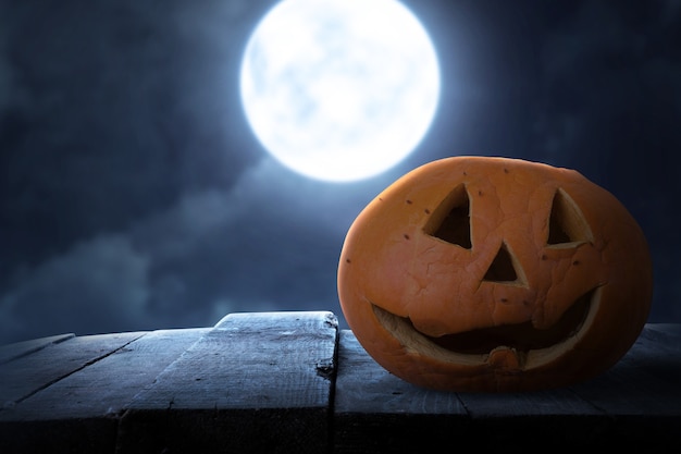 Jack-o-Lantern sur une table en bois avec le fond de scène de nuit