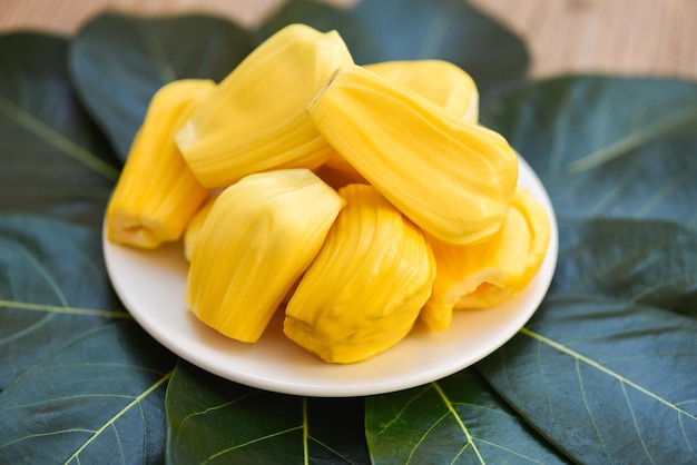 Jacquier mûr fruits tropicaux pelés frais de l'arbre de jacquier Jacquier sur plaque blanche et fond de feuille verte