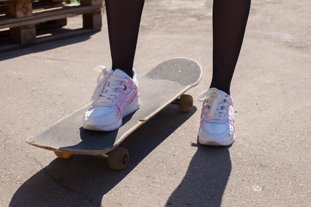 La jambe d'une fille sur le skateboard