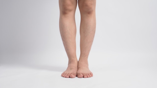 Jambes aux pieds nus masculins asiatiques isolés sur fond blanc.