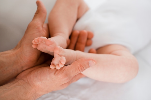 Jambes de bébé dans les mains