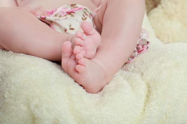 Jambes de bébé enfant nouveau-né les jambes des jambes du nouveau-né sur les pieds de l'enfant fond vert