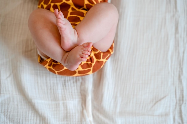 Jambes de bébé potelé mignon sur une feuille blanche