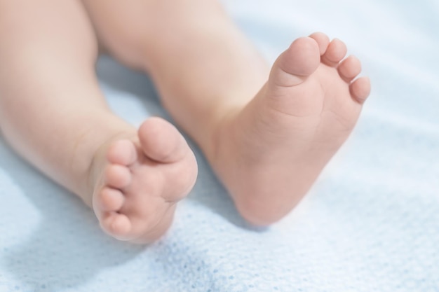 Les jambes de bébé reposent sur une couverture bleue Santé du bébé Motricité des jambes