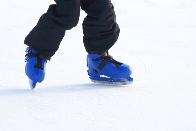 Jambes en bleu patinage sur la patinoire