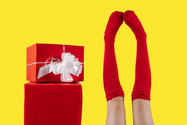 Jambes avec des chaussettes rouges à côté d'un cadeau rouge