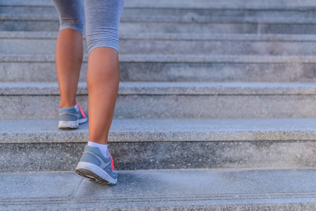 Jambes et chaussures d&#39;un jogger courant dans un escalier