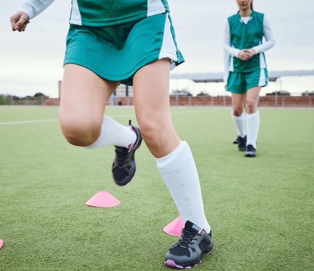 Jambes coniques ou équipe courant pour un entraînement de vitesse et un exercice d'échauffement sur un gazon de hockey en plein air Chaussures d'équilibre en gros plan ou sportifs sur un terrain en herbe jouant dans un jeu d'entraînement pour le fitness