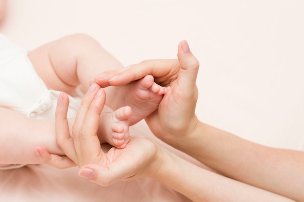 Les jambes du bébé dans les mains de la mère ont la forme d'un foyer, d'un coeur