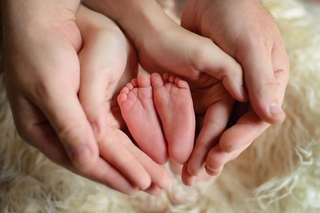 Les jambes du bébé sont entre les mains des parents Journée de la protection des enfants