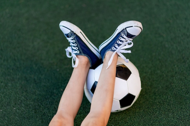 Photo jambes de l'enfant sur un ballon de soccer