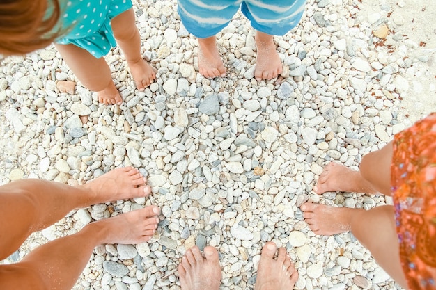 jambes de famille dans le sable de la mer