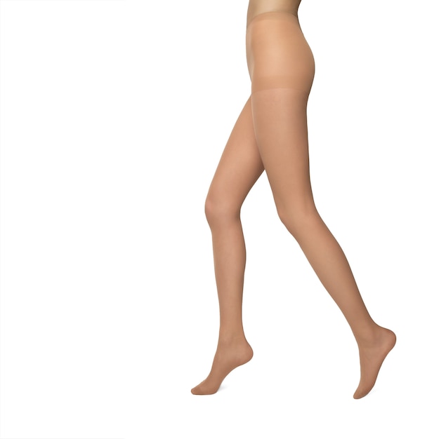 Jambes féminines en collants couleur peau isolés sur fond blanc