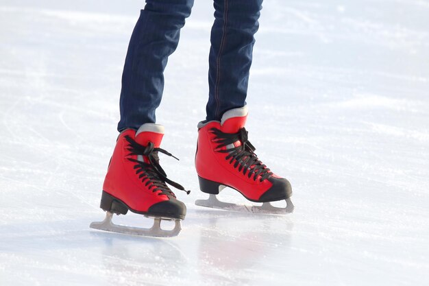 Jambes féminines en patins sur une patinoire