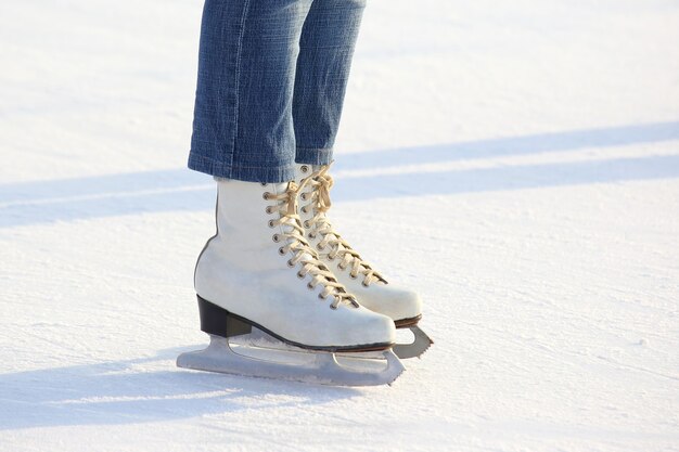 Jambes féminines en patins sur une patinoire