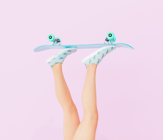 jambes féminines avec planche à roulettes