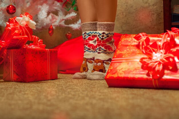Jambes de femme dans des chaussettes de Noël drôles. Ambiance de Noël. Nouvelle année.