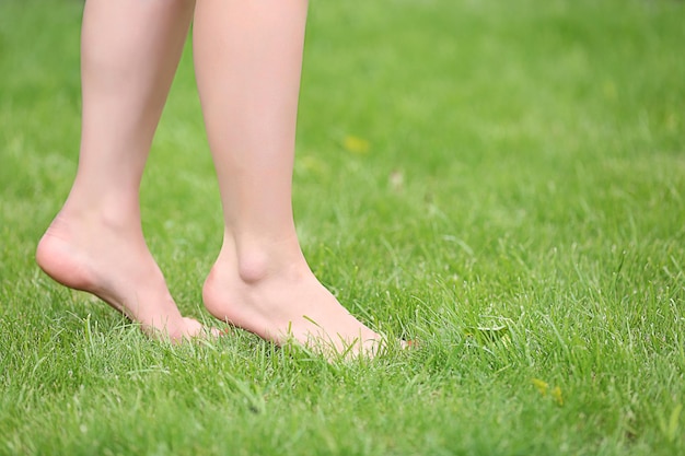 Jambes de femme sur l'herbe verte