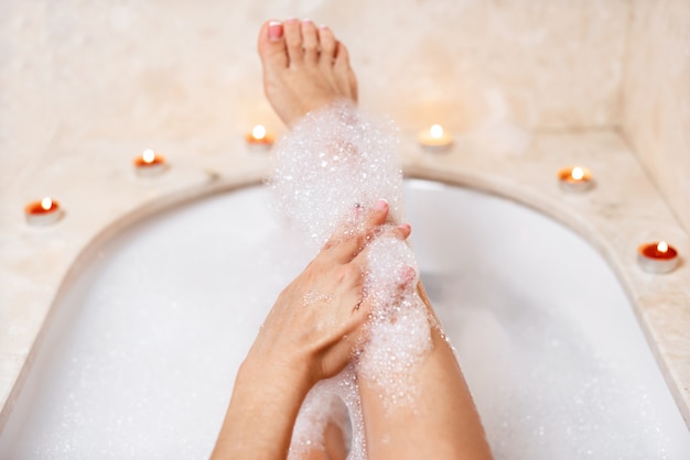 Jambes de femme en mousse de bain. Détente en spa.