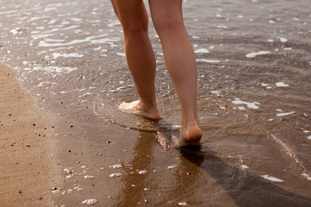 Les jambes de la femme se bouchent sur le bord de la mer