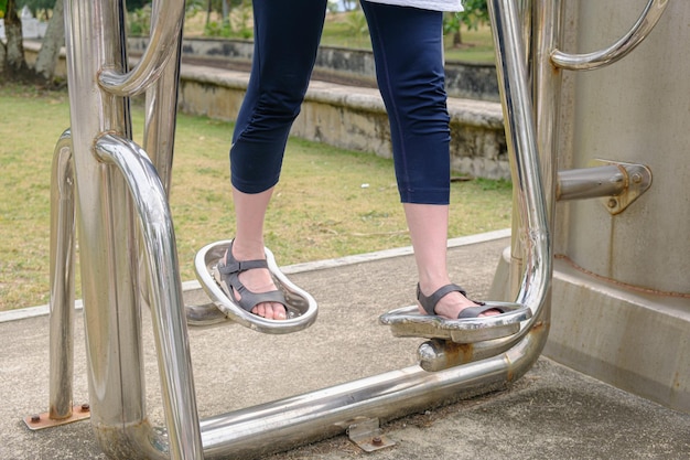 Jambes de femmes sur un simulateur de métal extérieur imitant la marche