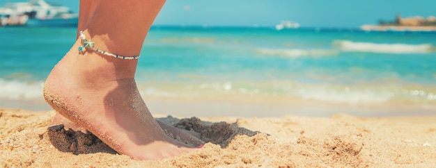 Jambes d'une fille au bord de la mer.