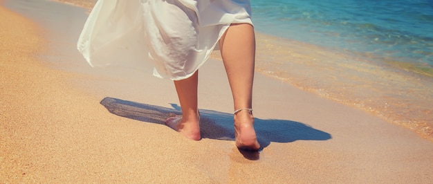 Jambes d'une fille au bord de la mer.