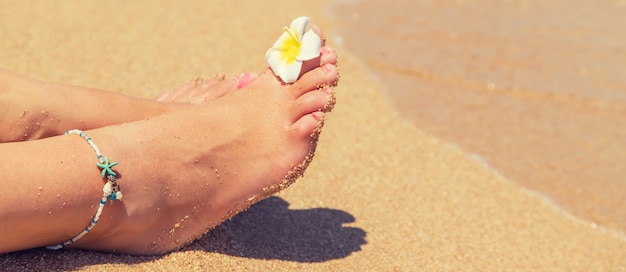 Jambes d'une fille au bord de la mer.