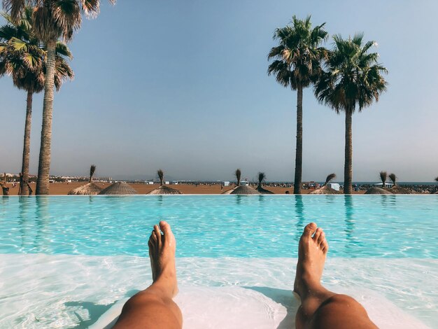 Jambes d'homme dans une piscine de luxe