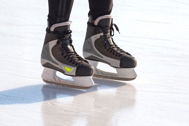 Jambes d'un homme patinant sur une patinoire. Loisirs et sports. Vacances et activités hivernales