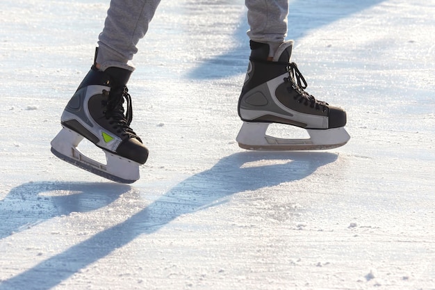 Jambes d'un homme patinant sur une patinoire. Loisirs et sports. Vacances et activités hivernales.