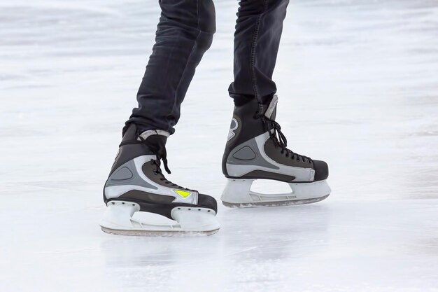 Jambes d'un homme patinant sur une patinoire. Loisirs et sports. Vacances et activités hivernales.