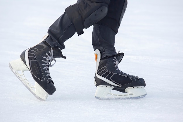 Jambes d'un homme patinant sur une patinoire. Passe-temps et sports. Vacances et activités hivernales.