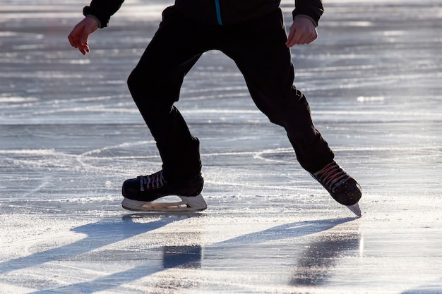 Jambes d'un homme patinant sur une patinoire.