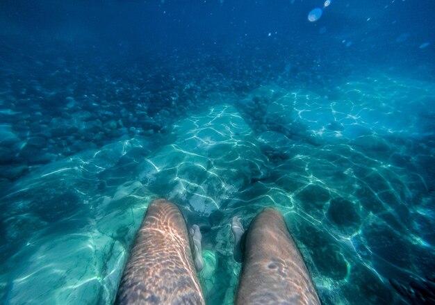 Les jambes d'un homme sous l'eau sur la côte d'Abkhazie