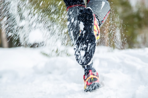 Jambes d&#39;un jeune coureur dehors en hiver nature