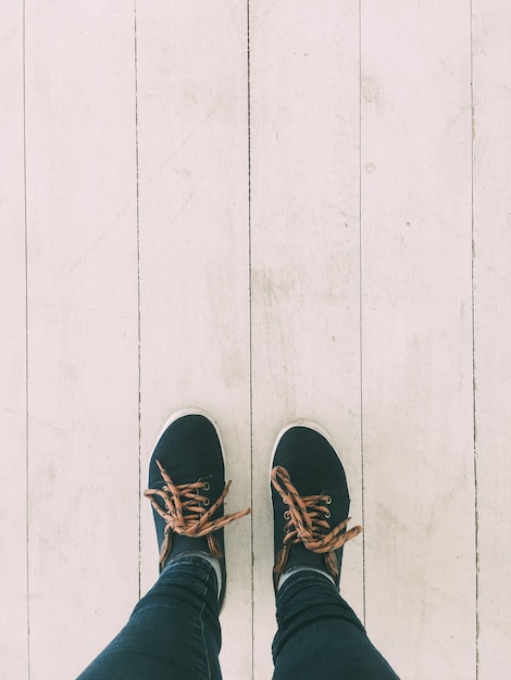 Les jambes de la jeune fille restent sur le plancher en bois