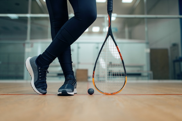 Jambes de joueuse, raquette de squash et balle. Fille sur la formation de jeu, passe-temps sportif actif sur le terrain, entraînement de remise en forme pour un mode de vie sain