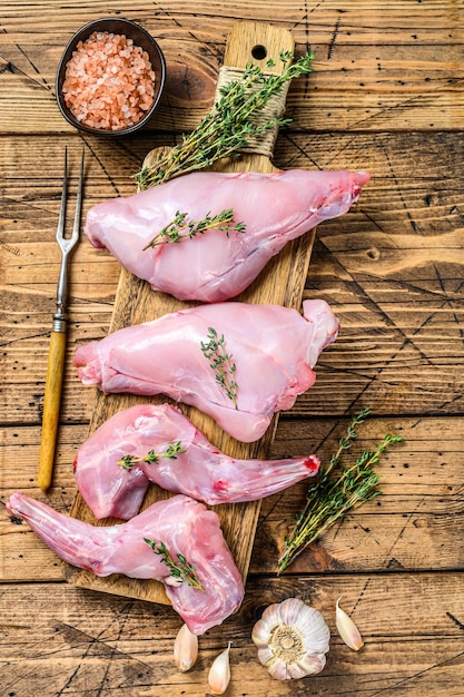 Jambes de lièvre cru sur une planche à découper